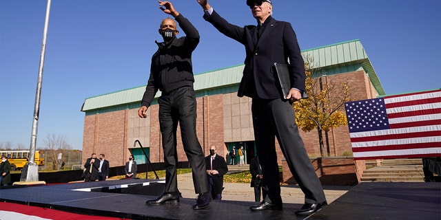 FILE - Biden and Obama wave to the audience at a rally at Northwestern High School in Flint, Mich., Saturday, Oct. 31, 2020. (AP Photo/Andrew Harnik)