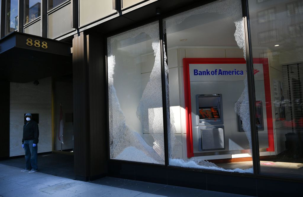 A broken window of a bank is seen on H Street, near the White House following riots in Washington, DC on June 1, 2020. - Police fired tear gas outside the White House late Sunday as anti-racism protestors again took to the streets to voice fury at police brutality, and major US cities were put under curfew to suppress rioting.With the Trump administration branding instigators of six nights of rioting as domestic terrorists, there were more confrontations between protestors and police and fresh outbreaks of looting. Local US leaders appealed to citizens to give constructive outlet to their rage over the death of an unarmed black man in Minneapolis, while night-time curfews were imposed in cities including Washington, Los Angeles and Houston. (Photo by MANDEL NGAN / AFP) (Photo by MANDEL NGAN/AFP via Getty Images)