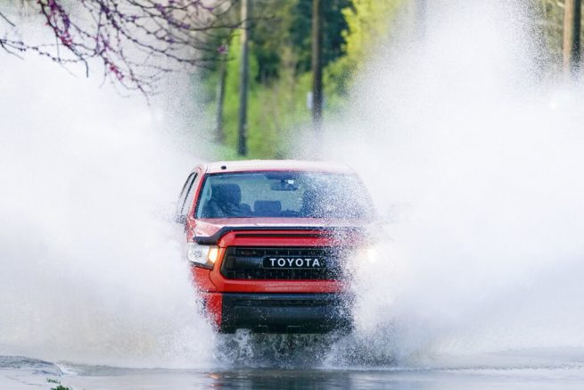 A truck drives through water on the road Sunday, March 28, 2021, in Nashville, Tenn. Heavy rain across Tennessee late Saturday and early Sunday flooded homes and roads as a line of severe storms crossed the state. (AP Photo/Mark Humphrey)